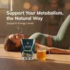 A woman in a green sports bra and leggings lies on a wooden floor in a warm, sunlit room, with a pouch of Daily Bio Active herbal tea and a glass mug of tea in the foreground. Text on the image reads: 'Support Your Metabolism, the Natural Way' and 'Supports Energy Levels'.